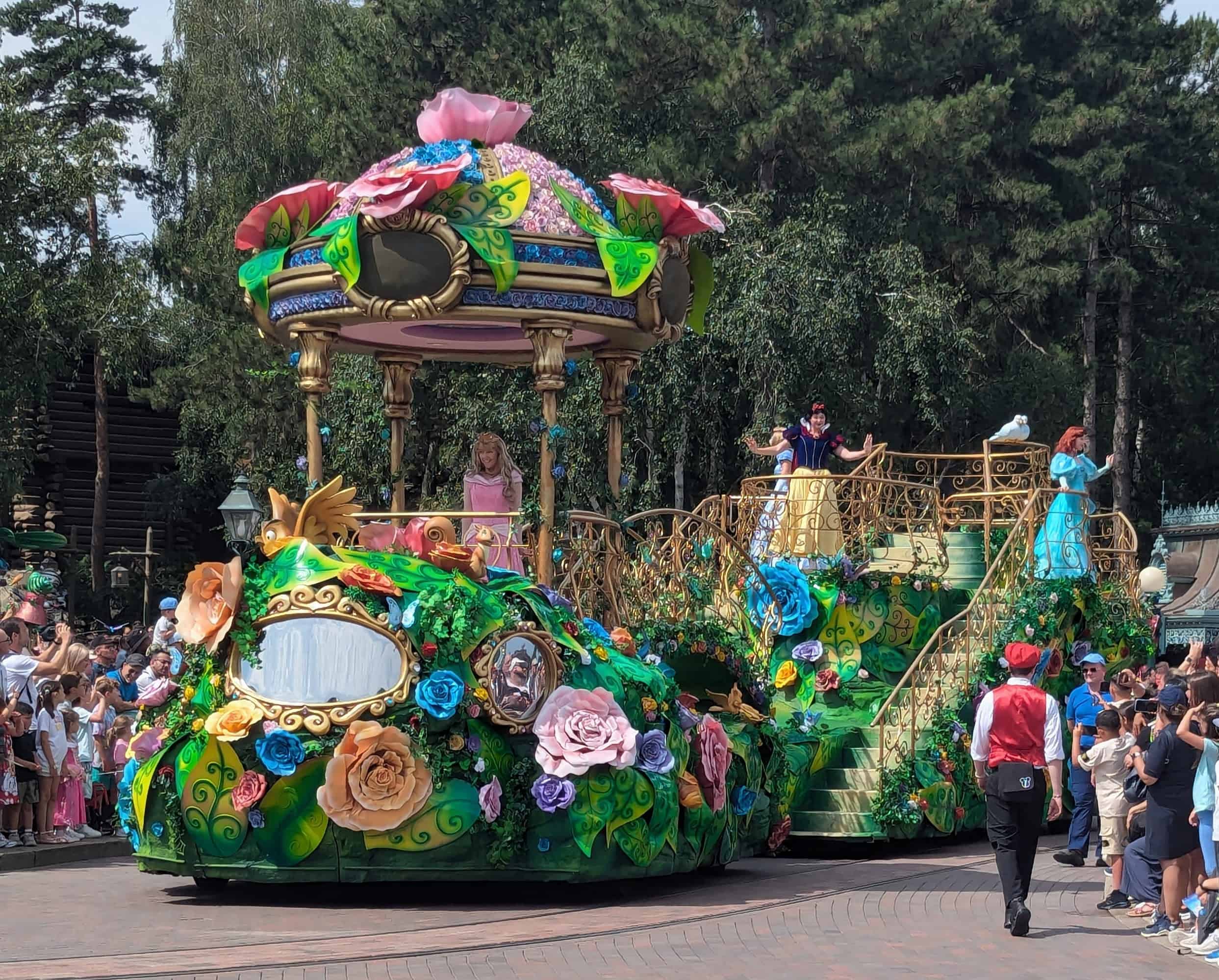 Snow White, Ariel, Cinderella, and Sleeping Beauty on a princess parade float going down Main Street at Disneyland Paris