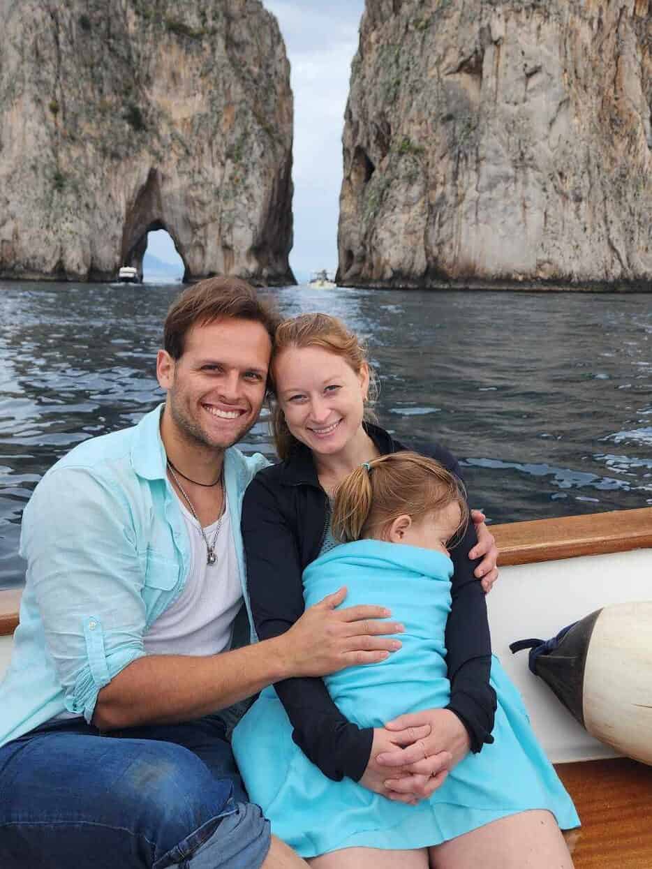 My family on a boat in Capri while my toddler sleeps on my lap using my scarf as a blanket