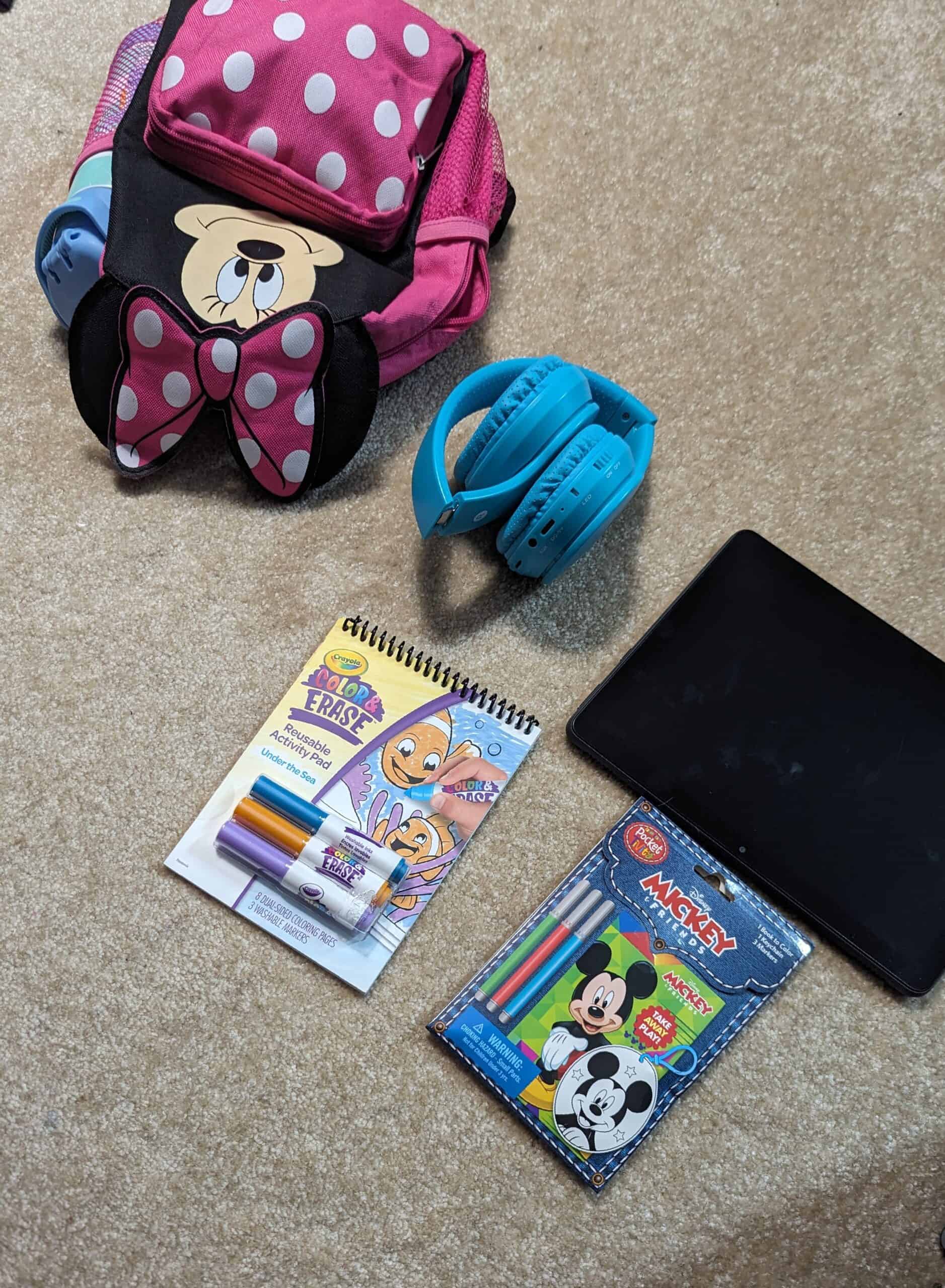 small coloring books, headphones, and tablet that I pack for my toddler